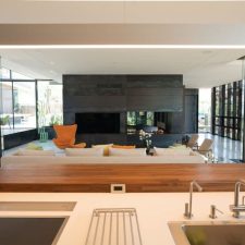 The view of a home with an open floor plan from the kitchen. Speakers are visible in the ceiling.