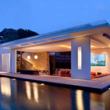 Beautiful lighting in an open-air room next to a pool.