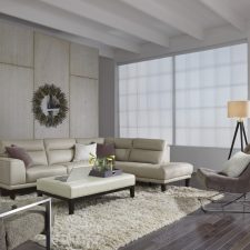 Beautiful, bright, modern living room with motorized window treatments and a large window.