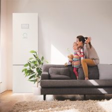 Mother and daughter playing together on a living room sofa.