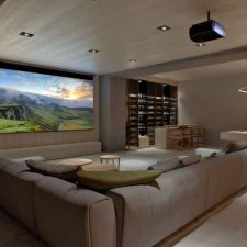 Modern home theater/media room with large sectional, screen and projector, pool table, and wine bar.